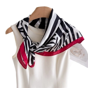 Silk-touch zebra print scarf with magenta borders on wood hanger against white background