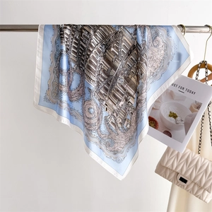 Detailed view of square silk scarf with blue borders and architectural prints on a hanger
