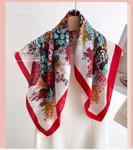 Detail of colorful floral silk scarf with vibrant red borders on a white dress