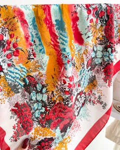 Close-up of floral print silk scarf with vibrant abstract patterns and red edges