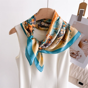 Floral silk scarf with orange and blue flower print styled on a white sleeveless top