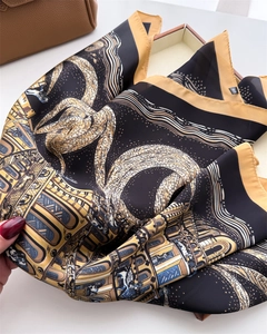 Detailed view of architecturally printed silk scarf showing soft drape and golden patterns