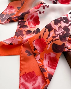 Gros plan détaillé d'un foulard en soie à fleurs dégradées avec imprimé rose rouge vif
