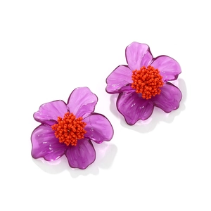 Macro detail of purple resin flower earrings with vibrant orange beaded centers