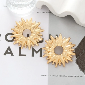 Retro hollow golden sunflower earrings with hammered texture on minimalist magazine setup