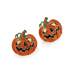 Détail des boucles d'oreilles citrouille d'Halloween avec émail orange et strass rouges
