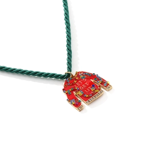 Détail macro d'un pendentif pull de Noël avec cristaux colorés et texte festif
