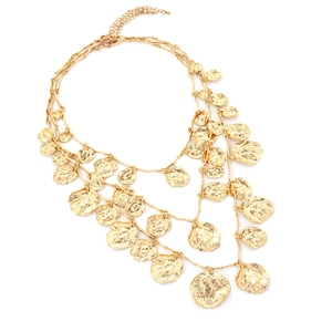 Three-layer gold necklace with irregular hammered metal discs on a plain white background