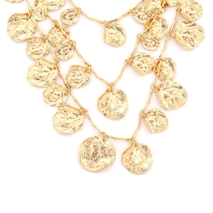 Close-up of triple-layered gold necklaces with irregular hammered coin charms