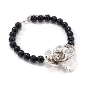 Retro statement necklace featuring large silver flower pendant and black resin beads
