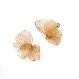 Detailed macro view of gold flower earrings showing intricate wire mesh texture and metallic shine