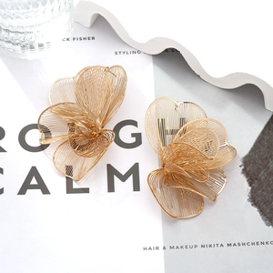 Exaggerated large gold floral stud earrings featuring intricate layered metallic petals