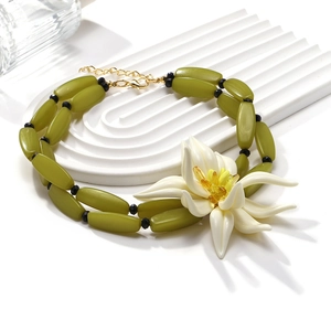 Collier de perles vert olive orné d'un grand pendentif en forme de fleur de lys blanc