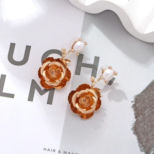 Elegant gold camellia flower earrings with pearl accents and layered metal leaf petals