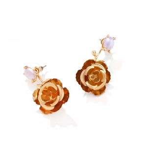 Macro shot of gold camellia flower earrings with a purple pearl stud and layered petals
