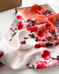 Détail macro d'un foulard en soie à imprimé floral sur un tissu satiné brillant