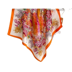 Floral print silk square scarf with orange borders and vibrant botanical garden patterns