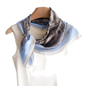 Sky blue and white architectural print silk scarf styled on a white sleeveless blouse