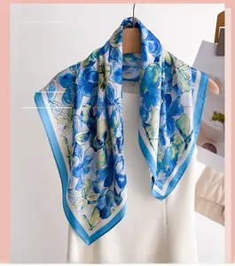 Detailed view of the blue floral print on a silky square scarf displayed on a mannequin