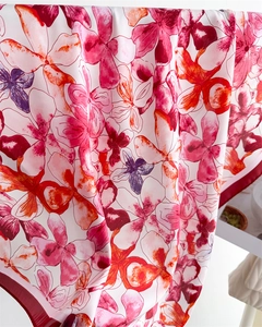 Detailed view of lightweight silk scarf featuring vibrant floral prints and dark red edges