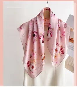 Détail d'un foulard en soie à fleurs roses sur un cintre avec une texture lisse