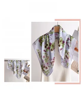 Détail d'un élégant foulard en soie aux motifs floraux suspendu à un cintre en bois