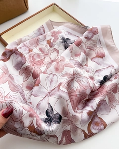 Close-up of floral print silk scarf with soft pink and purple tones and silky texture
