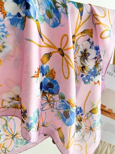 Détail d'un foulard en soie rose avec fleurs d'anémone bleues et motifs de cordes