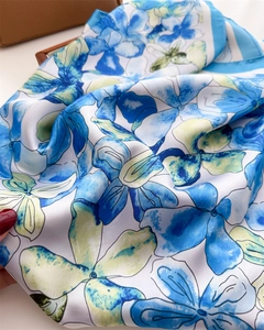 Close-up of floral silk scarf with elegant blue and yellow watercolor print texture