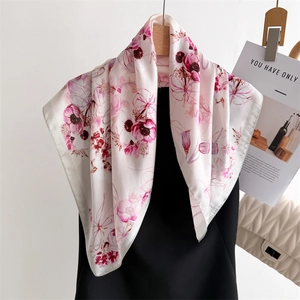 Carré de soie élégant aux motifs floraux roses et rouges sur cintre minimaliste
