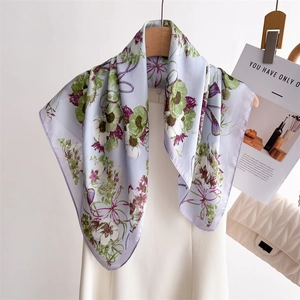 Foulard élégant en soie à imprimé floral lavande et bleu sur un cintre blanc