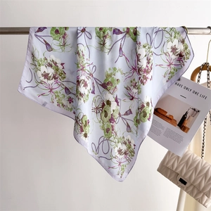 Vue détaillée d'un foulard en soie violet clair avec imprimé floral et motif de glands