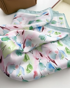 Dettaglio di un foulard in seta con eleganti motivi floreali e lucentezza satinata