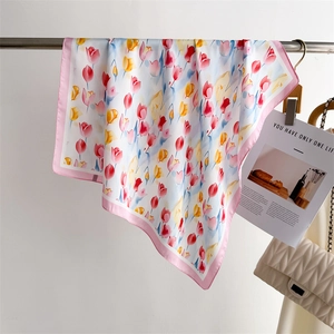 Dettaglio del foulard in seta con stampe di tulipani rosa e finitura liscia lucida