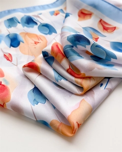 Dettaglio di una sciarpa in seta con stampe floreali di tulipani e trama in saia