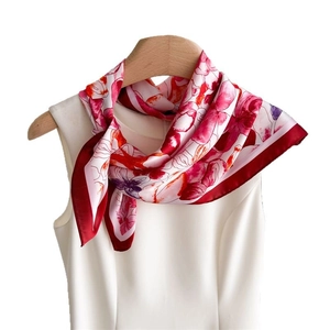 Elegant floral print silk square scarf with deep red borders styled on a mannequin