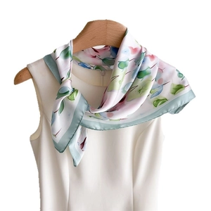 Elegante foulard di seta con stampa floreale rosa e verde su abito bianco