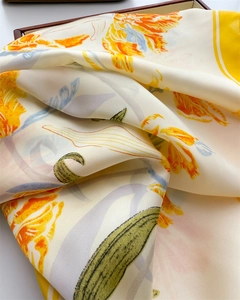 Detailed close-up of premium silk scarf with vibrant orange tulip print in a gift box