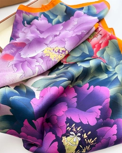 Close-up of floral silk scarf showing vibrant peony patterns and smooth satin texture