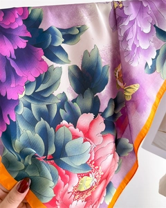 Close-up of satin scarf featuring floral peony patterns and orange contrast edges