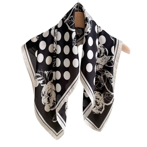 Foulard quadrato in seta a pois e stampa floreale appeso a una gruccia in legno bianca