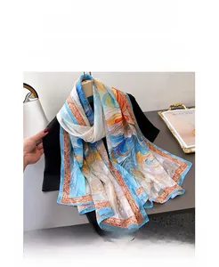Detail of elegant printed silk scarf with abstract blue and orange patterns on a model