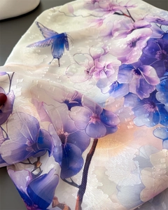 Close-up of floral print scarf fabric with blue butterfly and jacquard texture details