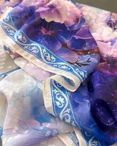 Detailed macro of floral print silk scarf featuring purple blossoms and blue border