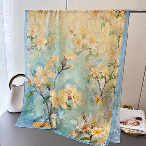 Detail of floral printed summer silk scarf featuring light green gradient and yellow blossoms