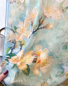 Detail of floral chiffon scarf showing sheer texture and delicate cherry blossom pattern