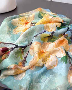 Detail showing soft light blue silk scarf fabric with jacquard texture and floral print