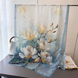Detail of elegant blue gradient floral scarf with white magnolia print for sun protection