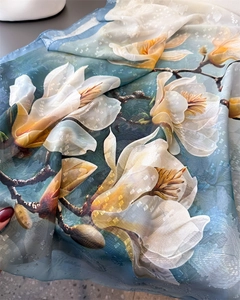 Close-up of floral jacquard silk scarf with elegant blue and green magnolia pattern