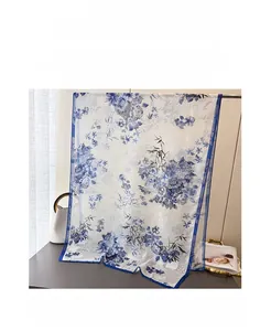 Détail d'une écharpe légère en mousseline à motifs floraux bleus et blancs